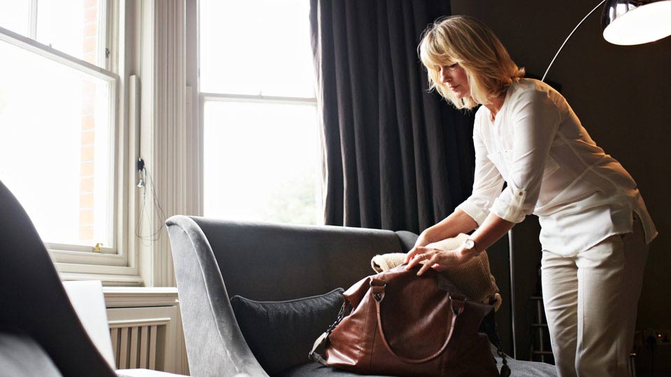Woman Packing Handbag with Belongings